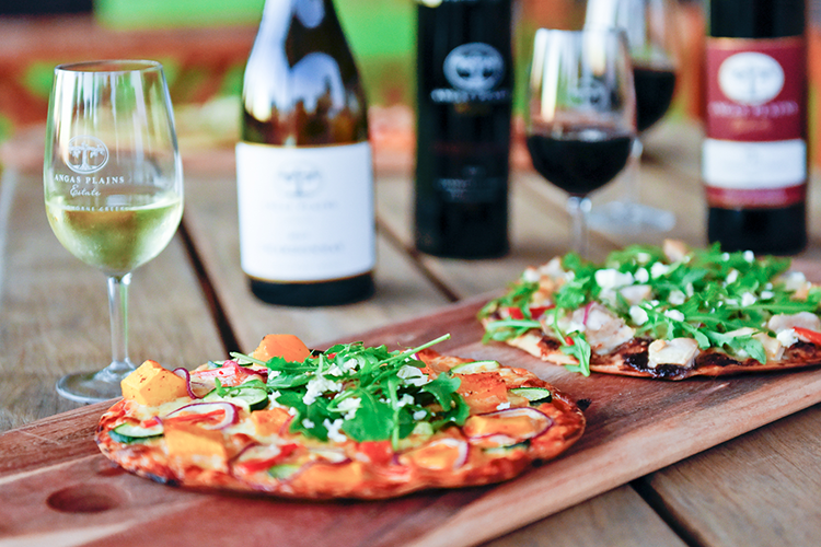 Table with wine bottles and pizza 